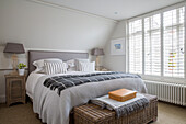 Double bed and blanket box at window with venetian blinds in West Sussex home