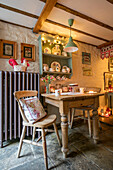 Wooden table and chairs with large radiator and fairylights in Georgian cottage Liverpool UK