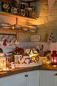 Lit candles and kitchenware in corner of Georgian cottage kitchen Liverpool UK