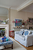 Light blue sofa with nautical artwork and striped red and white lampshades in Victorian terrace house South London UK
