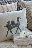 Grey camel on cushions with Christmas present in West Sussex farmhouse UK