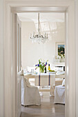 View through doorway to dining room with chandelier in West Sussex townhouse UK