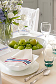 Cut flowers and apples with striped napkin at place setting in West Sussex townhouse UK