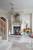 Pair of chairs with gilt framed mirror in spacious hallway of West Sussex townhouse UK
