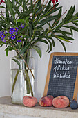 Schnittblumen und Pfirsiche mit Handschrift auf einer Tafel in einem provenzalischen Bauernhaus aus dem 19