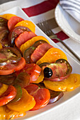 Sliced tomatoes and olive on plate in 19th century Provencal farmhouse France