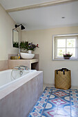 Blue and red floor tiles with bath and laundry basket in 19th century Provencal farmhouse France