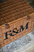 Weidenkorb mit den Buchstaben 'F&M' in einer umgebauten Scheune in Gloucestershire, England