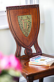 paperback books on antique wooden chair in terraced house Sevenoaks Kent UK