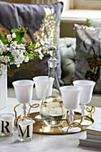 Decanter and goblets on gold tray with scented candles in detached Kent home UK
