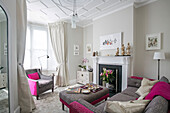 Graue und rosafarbene Polstermöbel im Wohnzimmer einer viktorianischen Terrasse in London UK