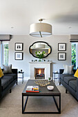 Pair of grey sofas with coffee table and it fire in living room of Surrey home UK