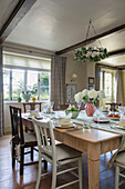 Mismatched chairs at square wooden dining table in Somerset home UK