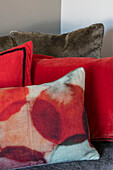 Bright red and tie-dyed cushions in North London home UK