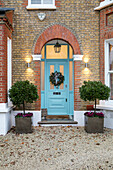 Abgeschnittene Bäume an einem mit blauem Grund gestrichenen Backsteineingang - Edwardianisches Haus in East Dulwich London UK