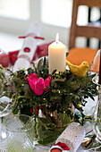 Lit candle in centrepiece with fabric birds on dining table in East Dulwich home London UK