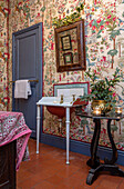 Fabric wallpaper and Christmas foliage in cloakroom of Georgian home Hertfordshire England UK