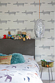 Silver pendant shade at bedside in child's room in London home UK
