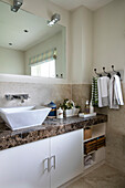 Washbasin and large mirror with towels on hooks in Kent bathroom UK