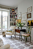 Vintage chairs and folding table with bookshelves in entrance of London home UK