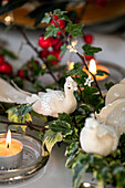 Bird ornament and lit tealight on dining table in Herefordshire home UK