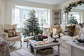 Christmas tree and armchair in bay window with sofa and table in Herefordshire newbuild UK