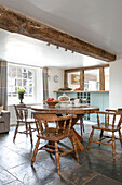 Wooden table and chairs under timber beamed ceiling in Kent cottage UK