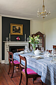 Patterned cloth on dining table with dark grey feature wall in Kent cottage UK