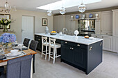 Open plan kitchen and dining room with skylight and glass pendants in Sussex home UK