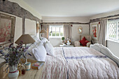 Bedside lamps and quilt with leaded windows in timber framed Surrey farmhouse UK