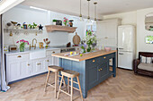 Barstools and parquet flooring with island unit in kitchen extension of Grade II listed country house Hertfordshire UK