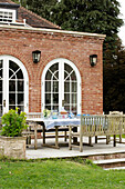 Patio furniture outside 1930s Georgian rectory extension West Sussex UK