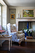 Wingback armchairs covered in Goose fabric at fireside in Wiltshire cottage UK