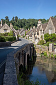 Straßenbrücke über einen Fluss mit Steinhäuschen in einem Dorf in Wiltshire UK
