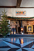 Christmas tree and woodburner with floorboards painted in star design Norfolk farmhouse UK