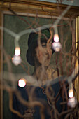 Gilt framed portrait of a woman and fairylights in Norfolk farmhouse UK