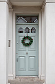 Christmas wreath and light green door to number 12 London UK