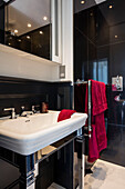 Black shower room with mirrored cabinet and red towels London townhouse UK