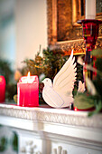 White dove and red candles on mantlepiece in Hampshire home UK