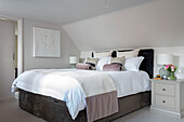 PInk velvet bolsters on doubel bed in Surrey cottage UK