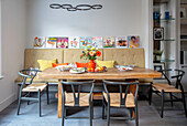 Bench seat and chairs at wooden dining table London UK