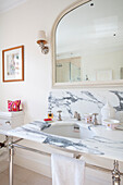 Großer Spiegel über einem Waschbecken aus Carrera-Marmor in einem Haus im Südwesten Londons (UK)
