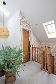 Gold patterned wallpaper and fern on landing of Sussex home UK