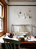 Place setting with Christmas decoration at wood framed window in Isle of Wight kitchen UK
