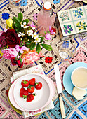 Erdbeeren und rosa Limonade mit Schnittblumen auf gehäkelter Tischdecke auf der Isle of Wight, Großbritannien
