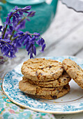 Biscuits on side plate with bluebells (Hyacinthoides non-scripta)