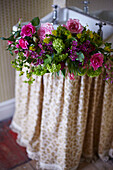 Vintage Blooms - Cut flowers in a hand basin with a vintage curtain and wallpaper