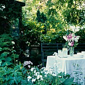 Hübsch gedeckter Mittagstisch in einem grünen Garten im Sommer