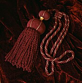 red and gold coloured ornate curtain tiebacks