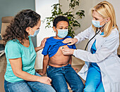 Doctor listening to boy's chest